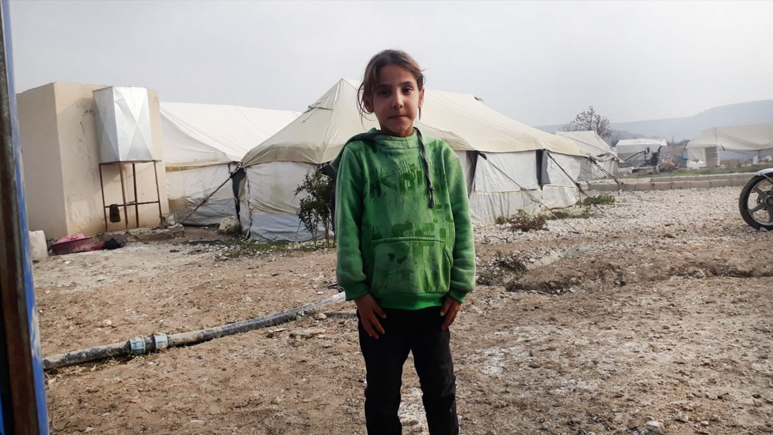 Five-year-old Miriam outside a camp for internally displaced people in Syria, which is currently her home.
