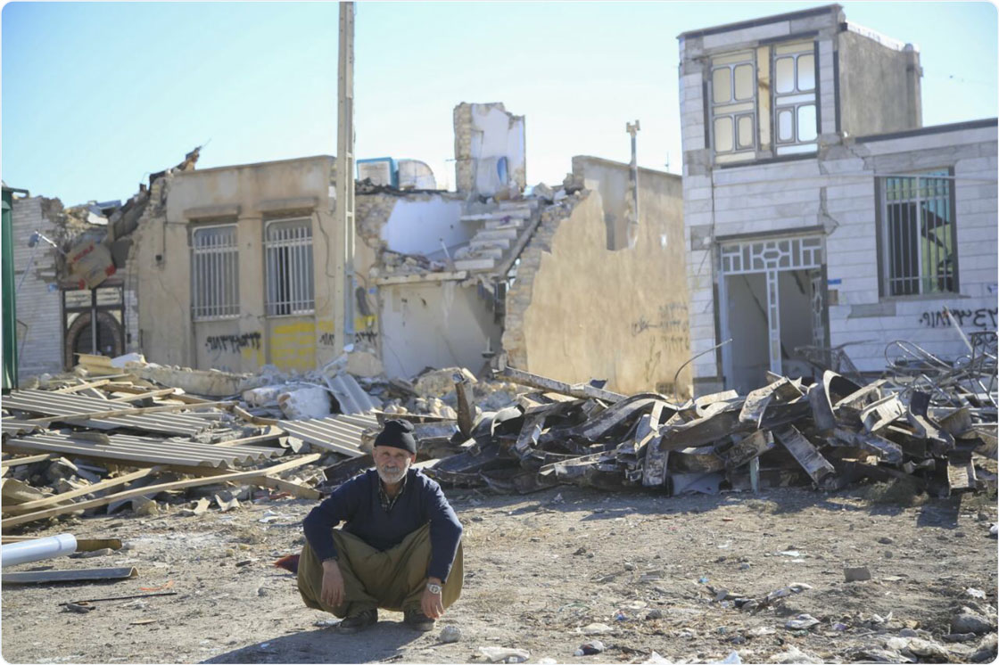 A man sits in front of the rubble of his former home, which was destroyed by a powerful 7.3 magnitude earthquake that struck along the Iran-Iraq border in late 2017. RI/RI Staff.