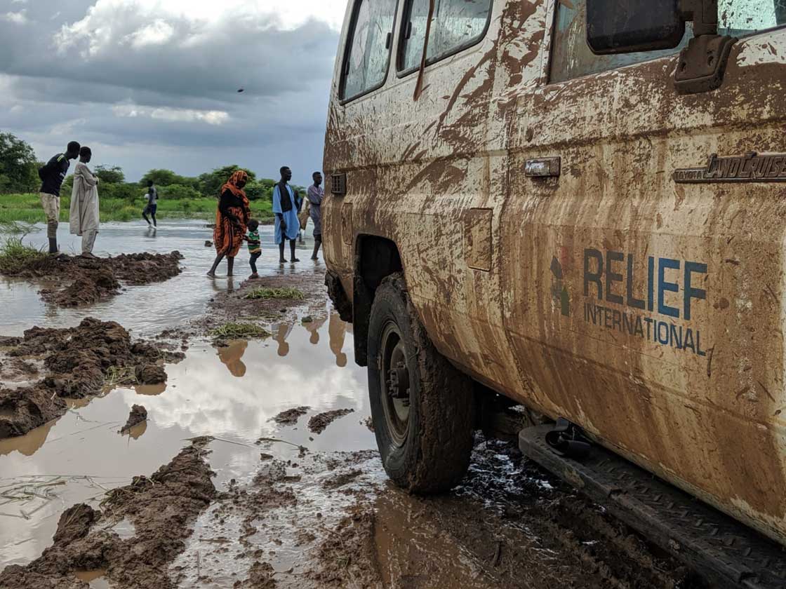 Relief International's team traverses a flooded dirt road in northeastern South Sudan to get to a clinic in a remote community. Elie Gardner/RI