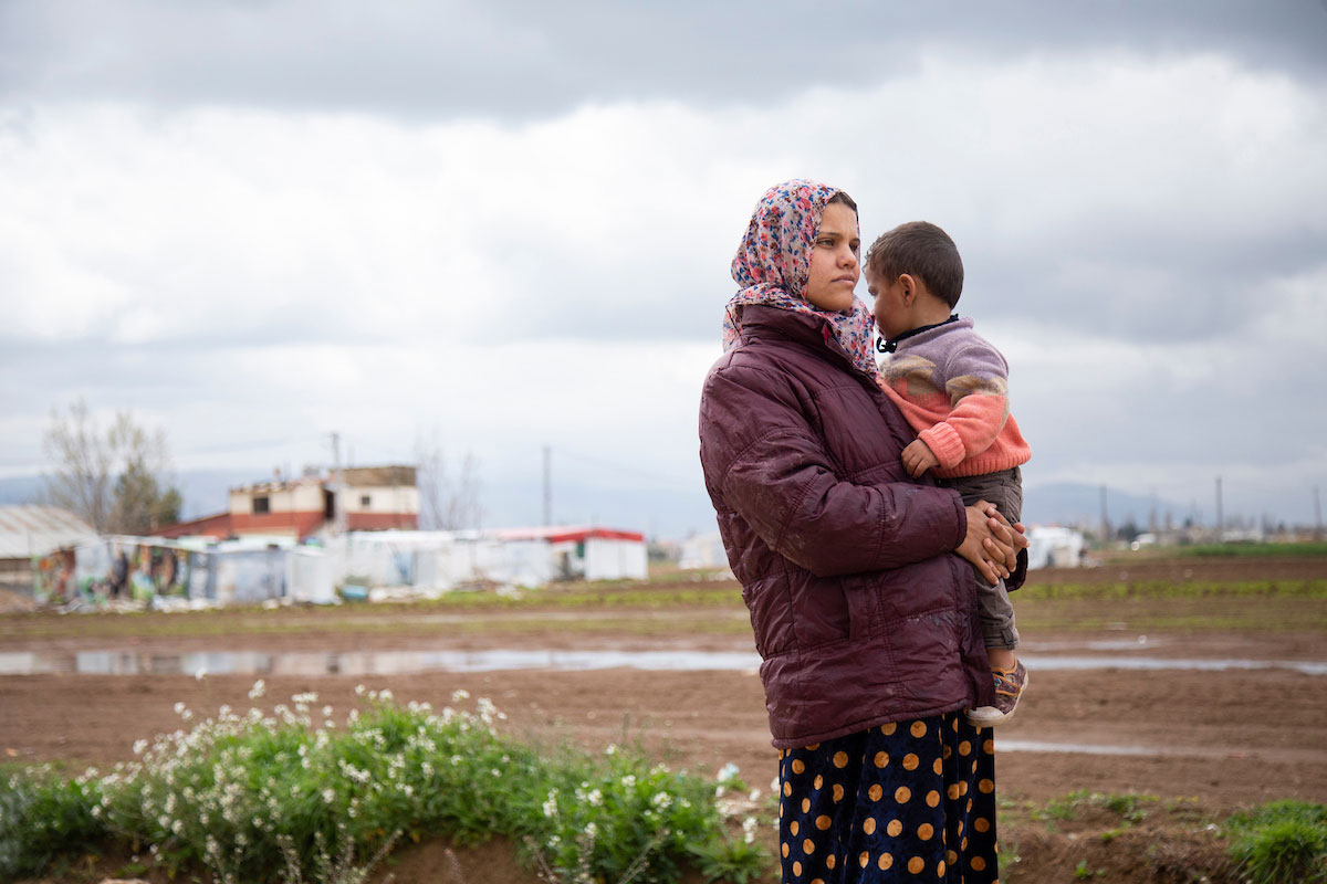 Randa holds her son Jasem, 2, in front of her makeshift shelter in Bekaa Valley, Lebanon. Elie Gardner/RI