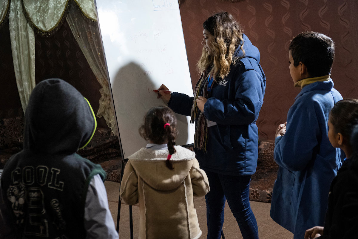 Relief International’s Education Field Assistant Layal Al Sayed checks students’ homework. Elie Gardner/RI