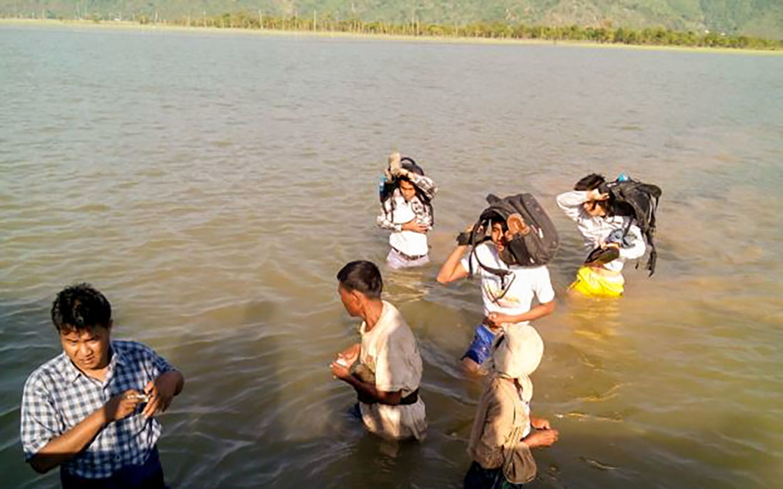 Our health teams wading through a river to reach remote communities in Myebon, Rakine State.