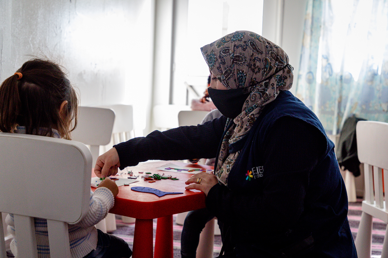 Suzan-teaching-ECD-Azraq-Camp-center-children-Arabic-letters-and-her-daughter-Sham-next-to-her-11.jpg